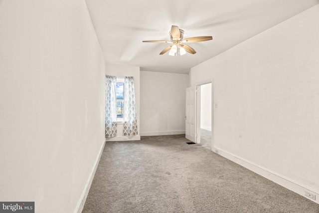 carpeted spare room with ceiling fan