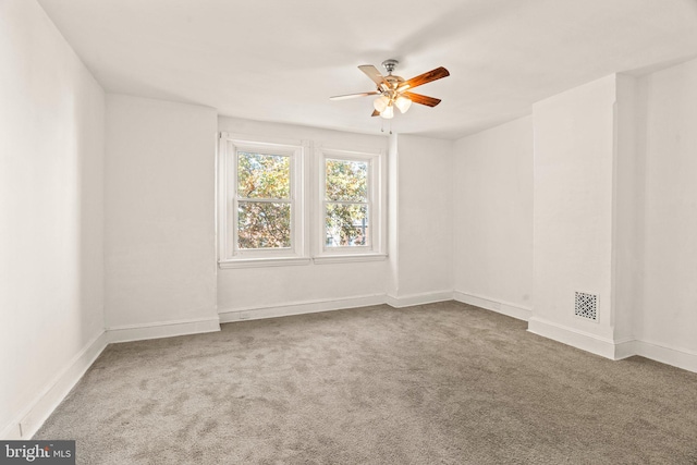 carpeted spare room featuring ceiling fan