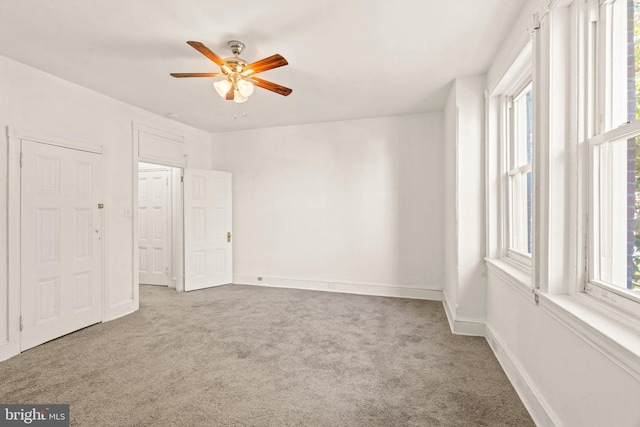 empty room featuring ceiling fan and carpet floors