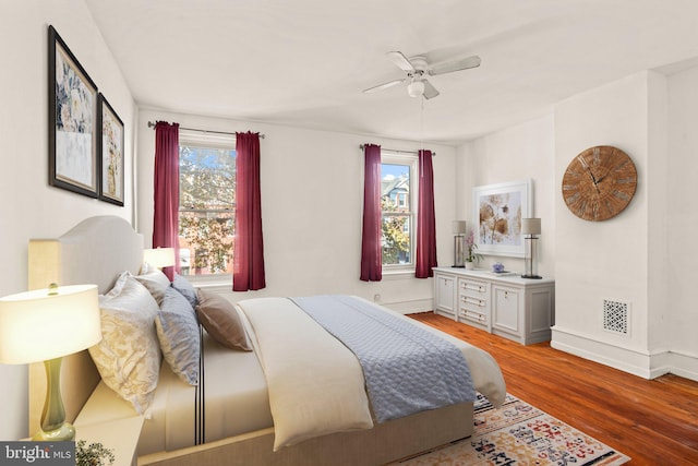 bedroom featuring hardwood / wood-style floors, multiple windows, and ceiling fan