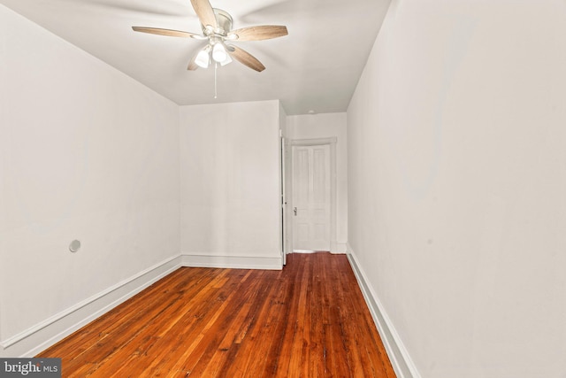 empty room with ceiling fan and dark hardwood / wood-style flooring