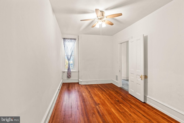 empty room with dark wood-type flooring and ceiling fan