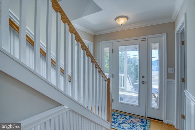 foyer featuring crown molding and light hardwood / wood-style flooring