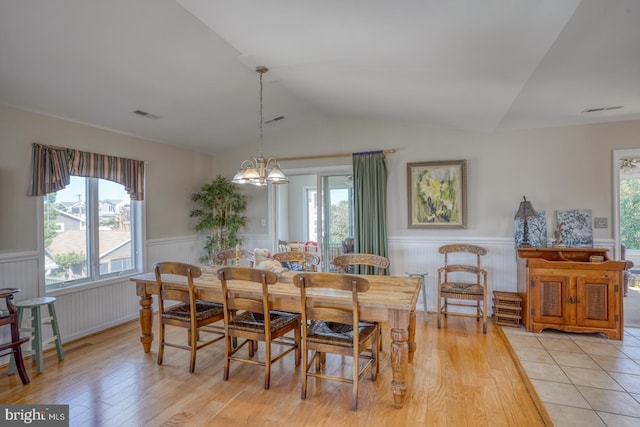 dining room featuring an inviting chandelier, lofted ceiling, and light hardwood / wood-style floors