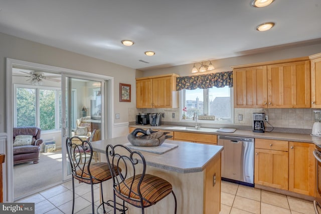 kitchen featuring a kitchen island, sink, a healthy amount of sunlight, and stainless steel dishwasher