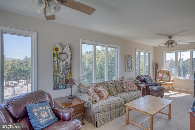 living room with plenty of natural light, light colored carpet, and ceiling fan