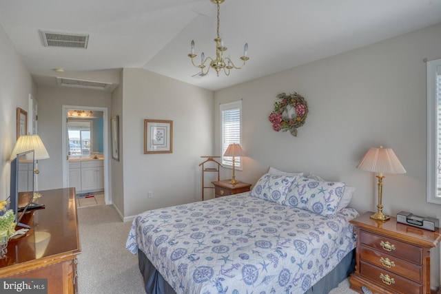 bedroom featuring an inviting chandelier, lofted ceiling, light colored carpet, and ensuite bathroom