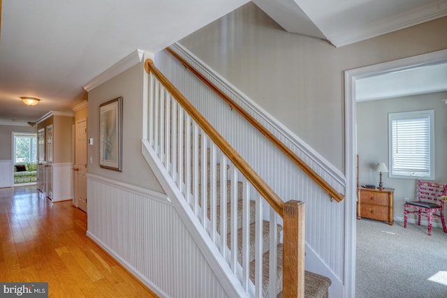 stairs with crown molding, hardwood / wood-style floors, and a wealth of natural light