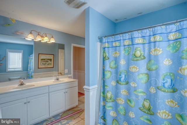 bathroom featuring tile patterned floors, vanity, and curtained shower