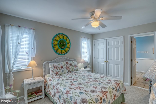 carpeted bedroom with ceiling fan and a closet