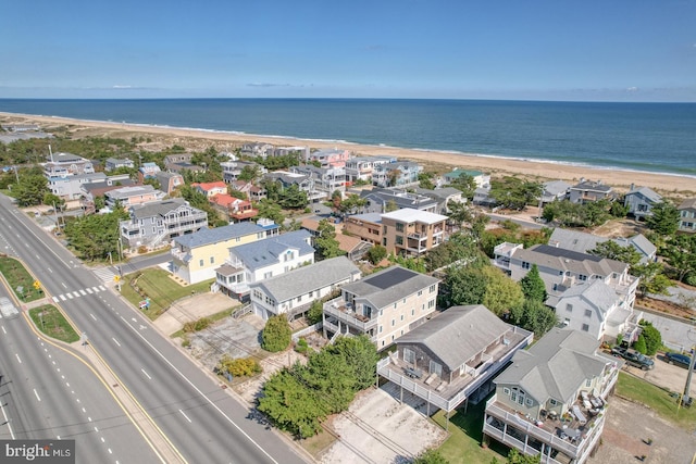 drone / aerial view featuring a water view and a view of the beach