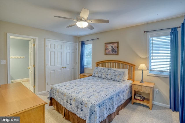 bedroom with ceiling fan, a closet, and light carpet