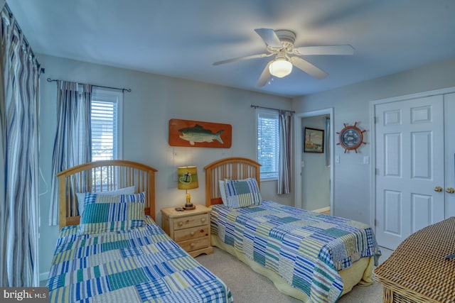 bedroom featuring multiple windows, ceiling fan, and light colored carpet