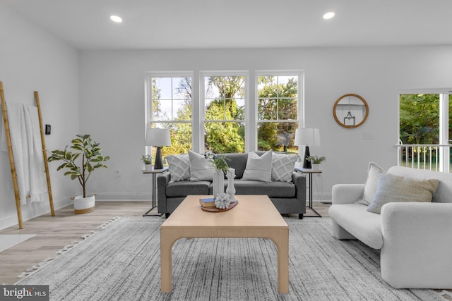 living area featuring baseboards, light wood-type flooring, and recessed lighting