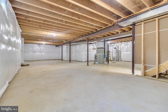 unfinished basement with gas water heater and heating unit