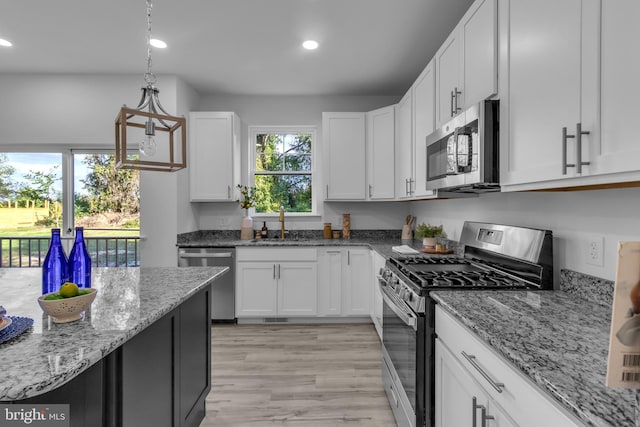 kitchen featuring recessed lighting, a sink, white cabinets, and appliances with stainless steel finishes