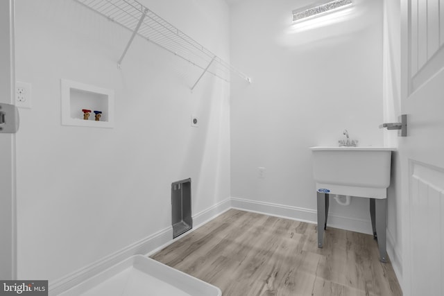washroom featuring hookup for an electric dryer, washer hookup, baseboards, wood finished floors, and laundry area