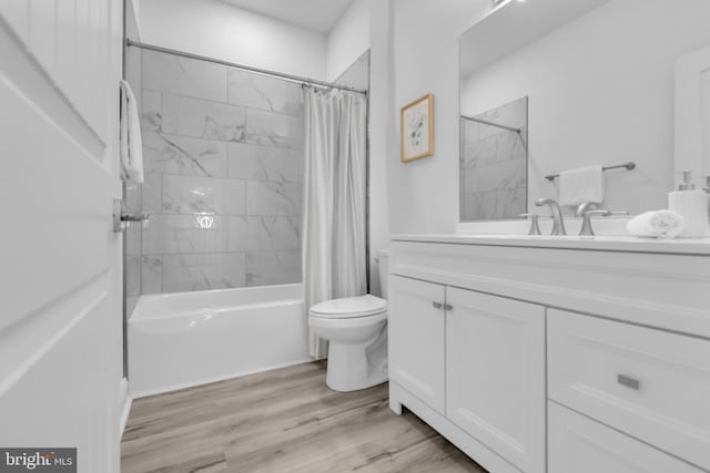 full bathroom with hardwood / wood-style floors, vanity, toilet, and shower / tub combo