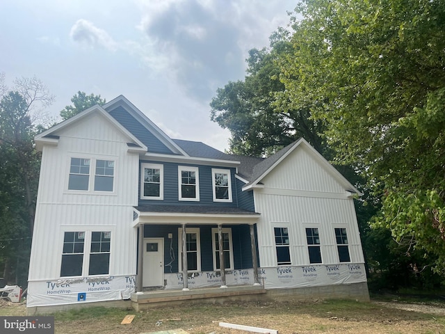 view of front of house with a porch, board and batten siding, and roof with shingles