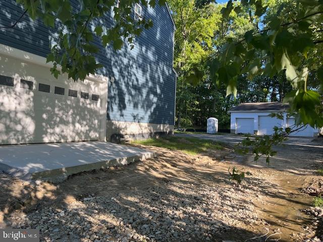 view of yard featuring a garage and an outbuilding