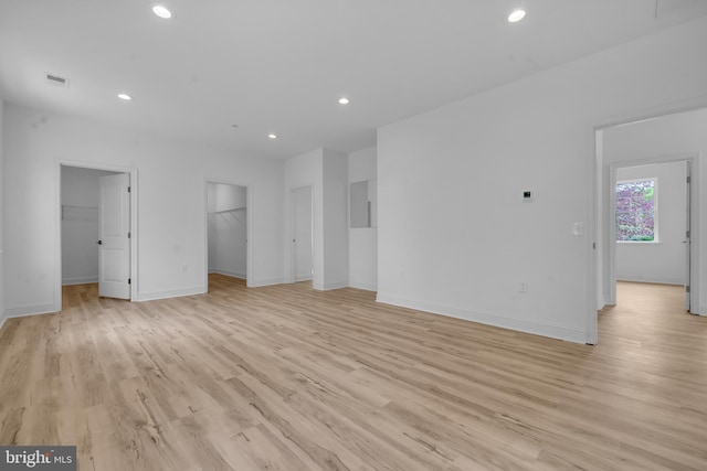 unfurnished living room with recessed lighting, light wood finished floors, visible vents, and baseboards