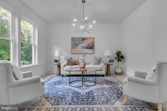 living room featuring wood finished floors, a chandelier, and baseboards