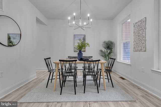 dining area featuring visible vents, a chandelier, wood finished floors, and baseboards