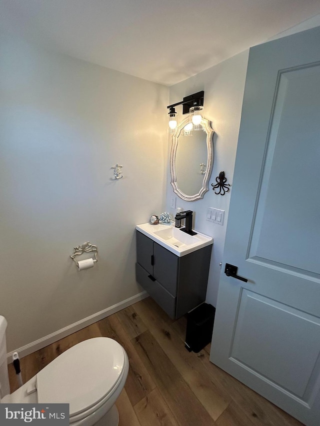 bathroom featuring hardwood / wood-style floors, vanity, and toilet