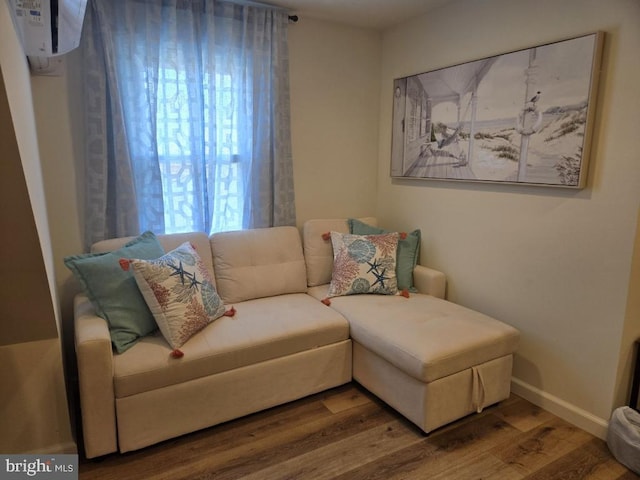 living room with an AC wall unit and hardwood / wood-style floors