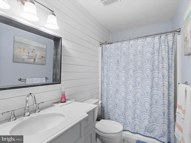 bathroom with walk in shower, wooden walls, vanity, and toilet