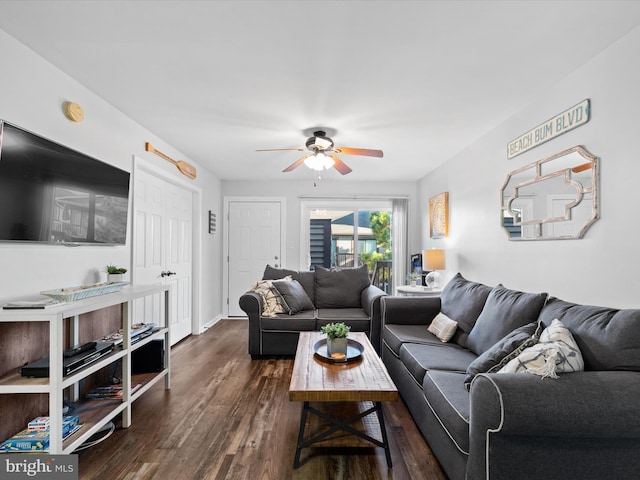 living room with ceiling fan and dark wood-type flooring