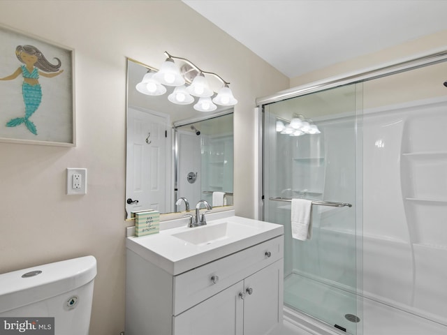 bathroom with a shower with door, vanity, and toilet