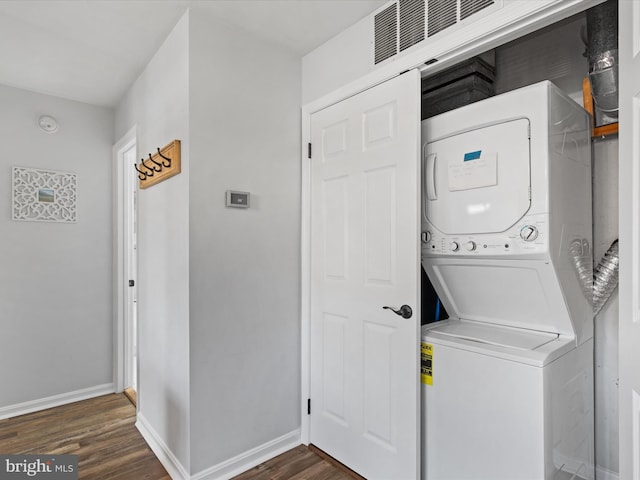 clothes washing area with stacked washer and clothes dryer and dark hardwood / wood-style floors