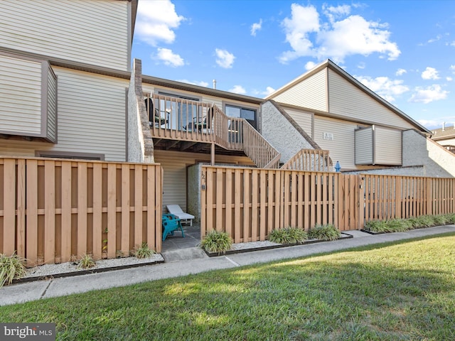 rear view of house with a deck and a lawn