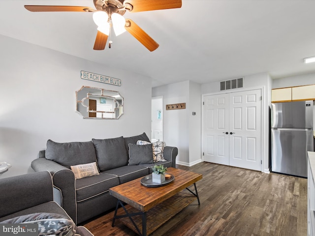 living room with ceiling fan and dark wood-type flooring