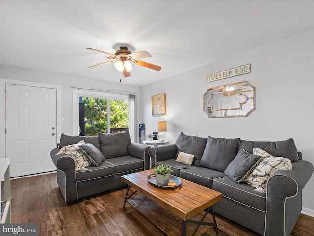 living room with ceiling fan and dark wood-type flooring