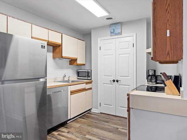 kitchen featuring stainless steel appliances, dark hardwood / wood-style flooring, and sink