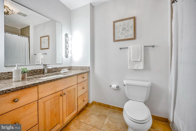 bathroom featuring tile patterned flooring, vanity, and toilet