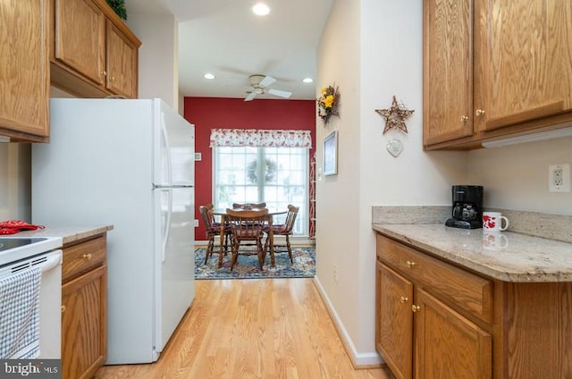 kitchen featuring light stone countertops, white electric range, light wood-type flooring, and ceiling fan