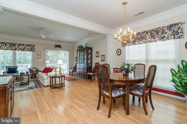 dining space with crown molding, light hardwood / wood-style flooring, and ceiling fan with notable chandelier