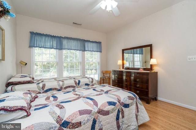 bedroom featuring light hardwood / wood-style flooring, multiple windows, and ceiling fan