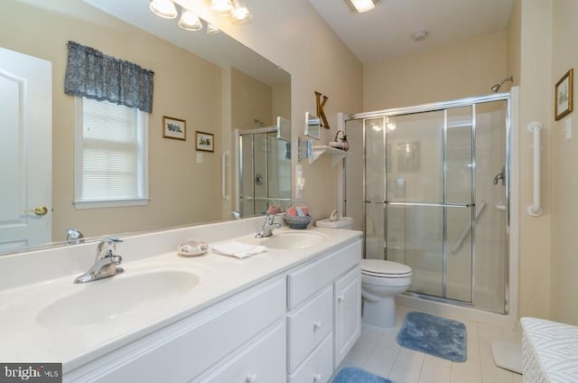 bathroom featuring a shower with door, toilet, tile patterned flooring, and vanity