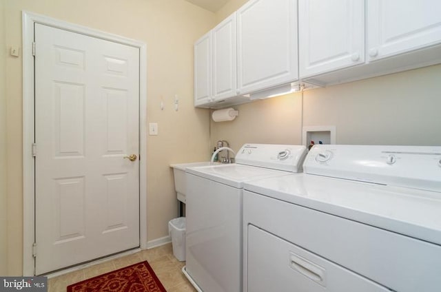 laundry area featuring light tile patterned floors, cabinets, and washing machine and clothes dryer