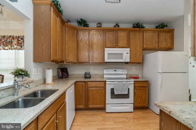 kitchen featuring light stone countertops, sink, light hardwood / wood-style floors, and white appliances