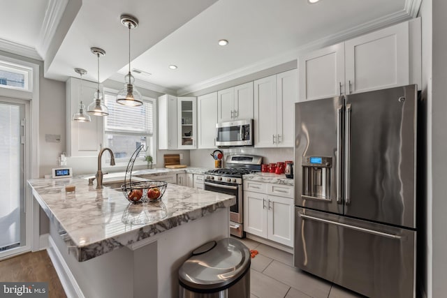 kitchen featuring light stone counters, white cabinets, a breakfast bar area, and stainless steel appliances