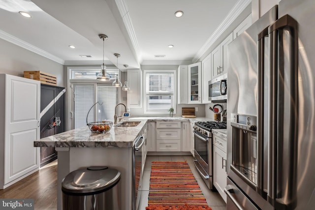 kitchen featuring white cabinets, appliances with stainless steel finishes, sink, and light stone counters