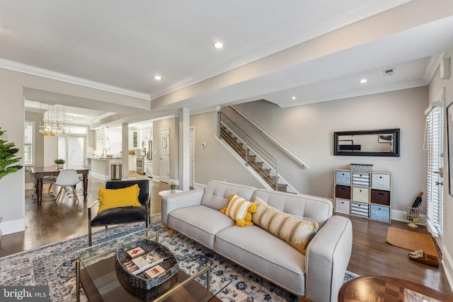 living room featuring sink, dark hardwood / wood-style floors, a chandelier, and crown molding