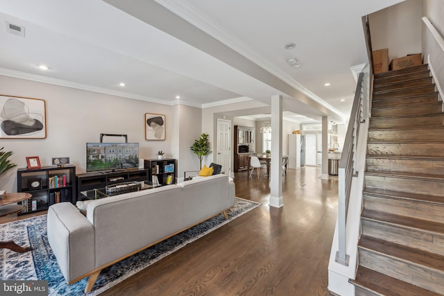 living room featuring a notable chandelier, crown molding, and dark hardwood / wood-style flooring