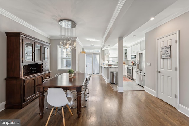 dining room featuring a notable chandelier, crown molding, and hardwood / wood-style flooring