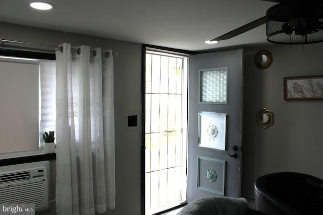 entryway featuring a wall mounted AC, plenty of natural light, and ceiling fan